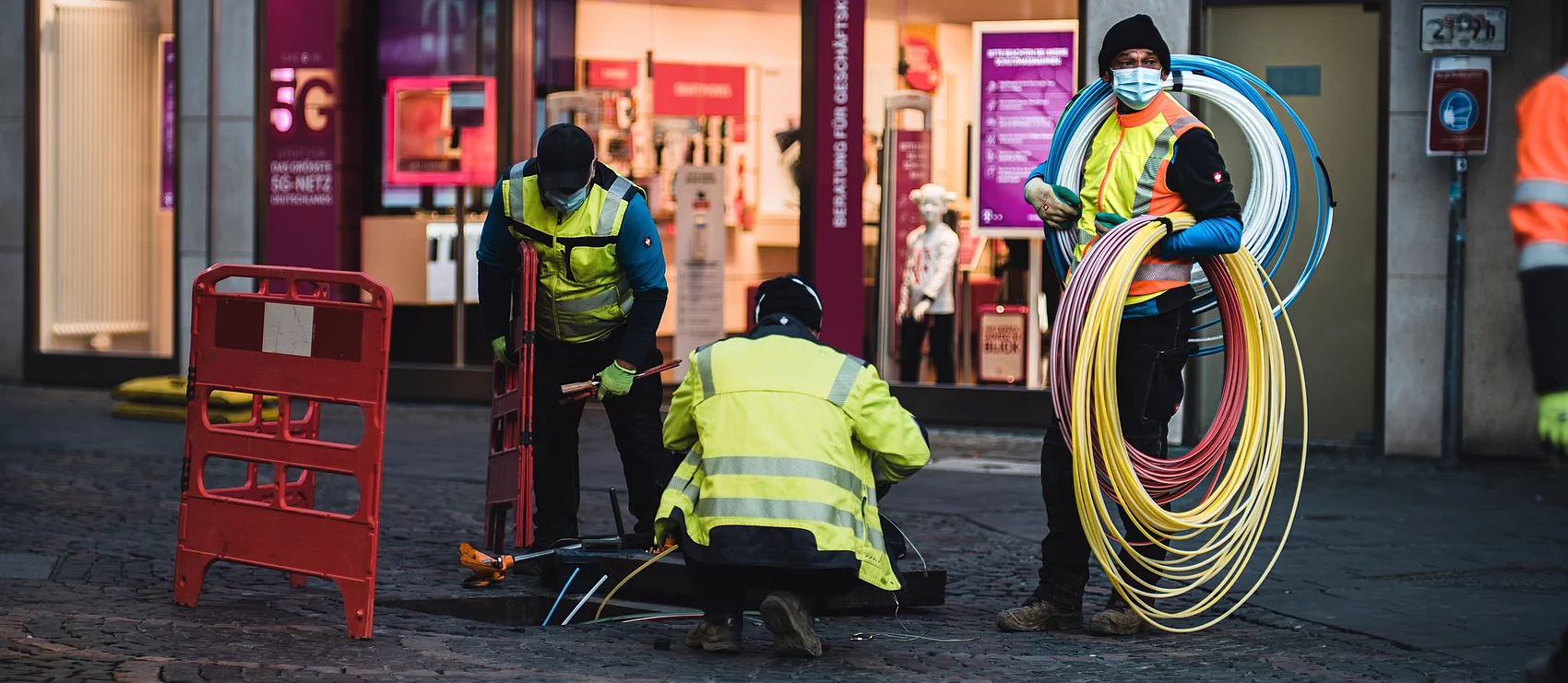 Symbolbild: Arbeiter verlegen Glasfaser-Leerrohre für den Breitbandausbau